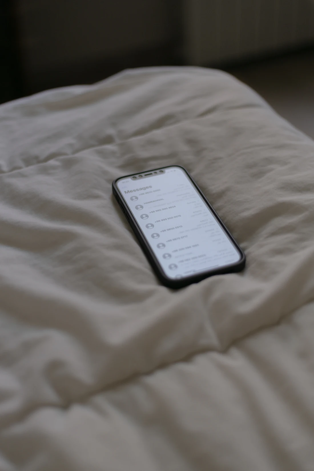 A phone lying on white bedding